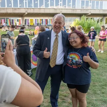 Chancellor greeting students on campus mall 